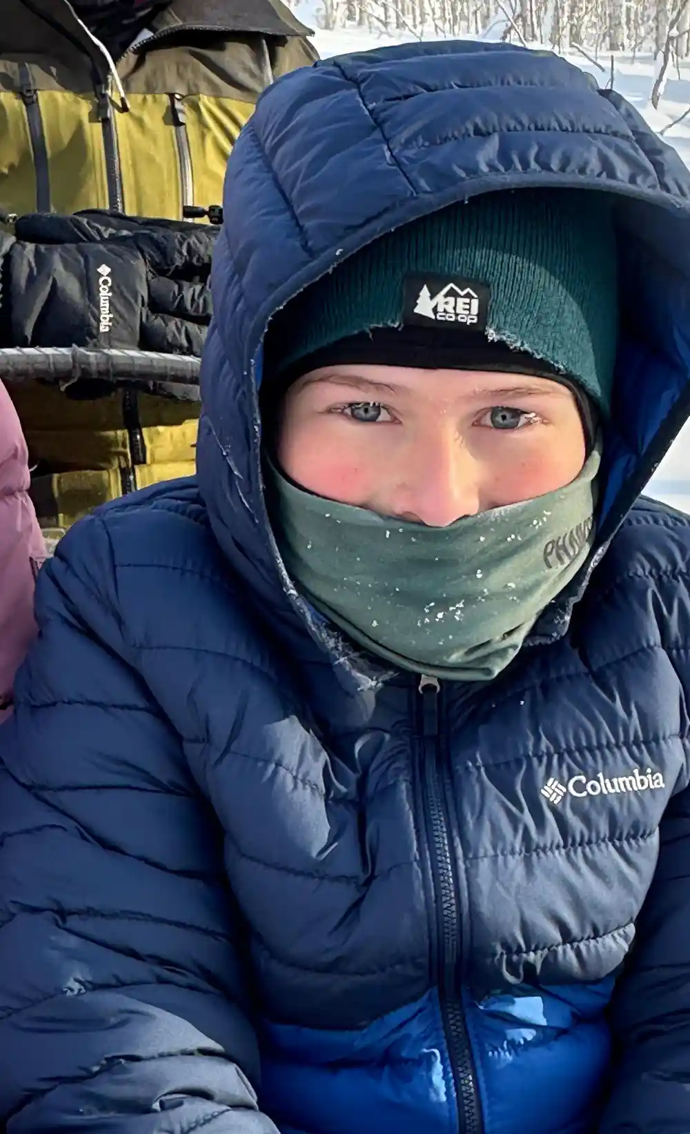 Visitor in a face covering and hood, frost on the fabric